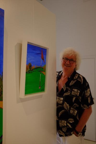 Portrait de benoît Renaux devant une de ses toiles lors de son exposition
